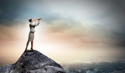 Image of businesswoman looking in telescope standing atop of rock