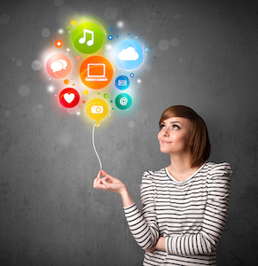 Pretty young woman holding colorful social media icons balloon