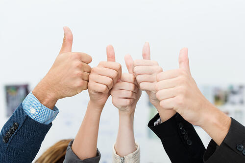 Successful diverse young business team giving a victorious thumbs up to show their success and motivation, close up view of their raised hands-2