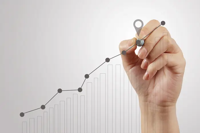 A woman holding a pen drawing lines on a board